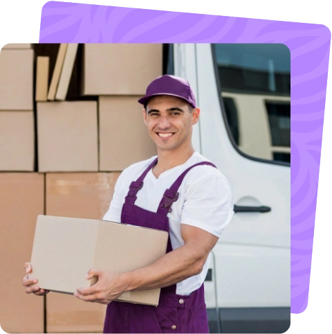 Smiling professional mover carrying a box in front of a moving van