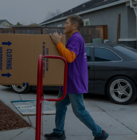 Mover moving a wardrobe box on a dolly for an apartment move